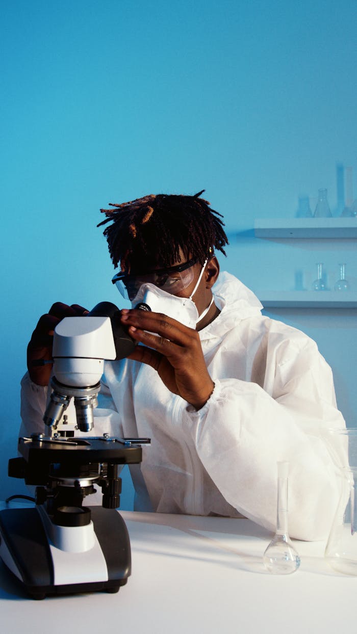 A professional scientist examines samples using a microscope in a modern laboratory setting.